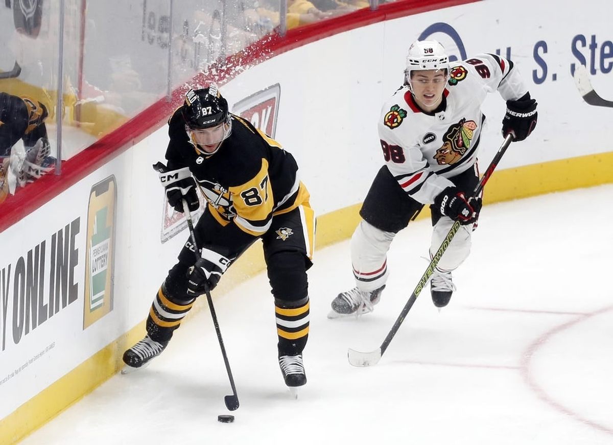 Oct 10, 2023; Pittsburgh, Pennsylvania, USA; Pittsburgh Penguins center Sidney Crosby (87) moves the puck ahead of Chicago Blackhawks center Connor Bedard (98) during the second period at the PPG Paints Arena. Chicago won 4-2.