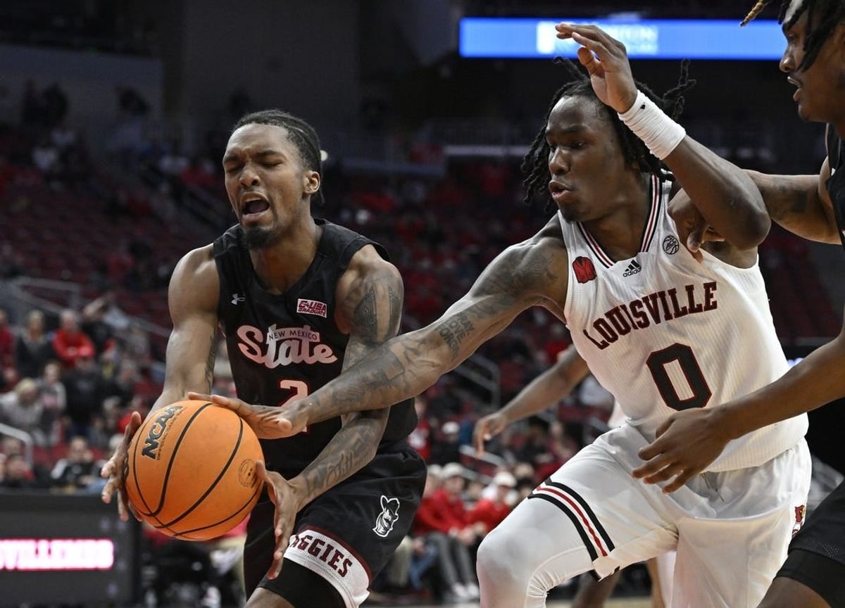 Nov 26, 2023; Louisville, Kentucky, USA;  Louisville Cardinals guard Mike James (0) scrambles for the ball against New Mexico State Aggies guard Jordan Rawls (2) during overtime at KFC Yum! Center. Louisville defeated New Mexico State 90-84.