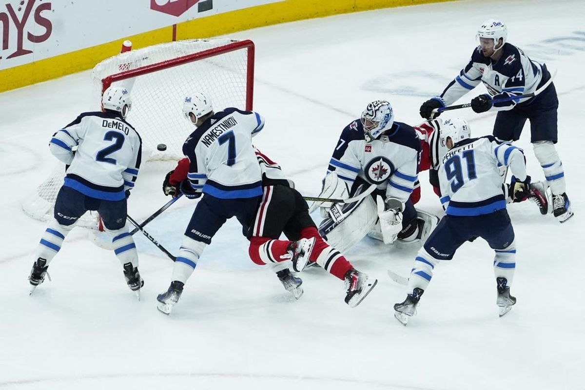 Dec 27, 2023; Chicago, Illinois, USA; Chicago Blackhawks center Connor Bedard (98) scores a goal on Winnipeg Jets goaltender Connor Hellebuyck (37) during the first period at United Center.