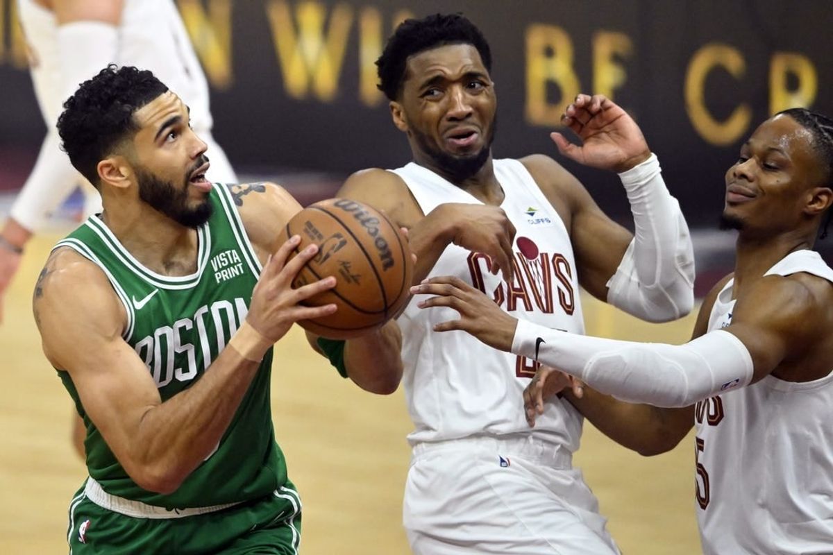 May 11, 2024; Cleveland, Ohio, USA; Boston Celtics forward Jayson Tatum (0) drives against Cleveland Cavaliers guard Donovan Mitchell (45) and forward Isaac Okoro (35) in the first quarter of game three of the second round of the 2024 NBA playoffs at Rocket Mortgage FieldHouse.