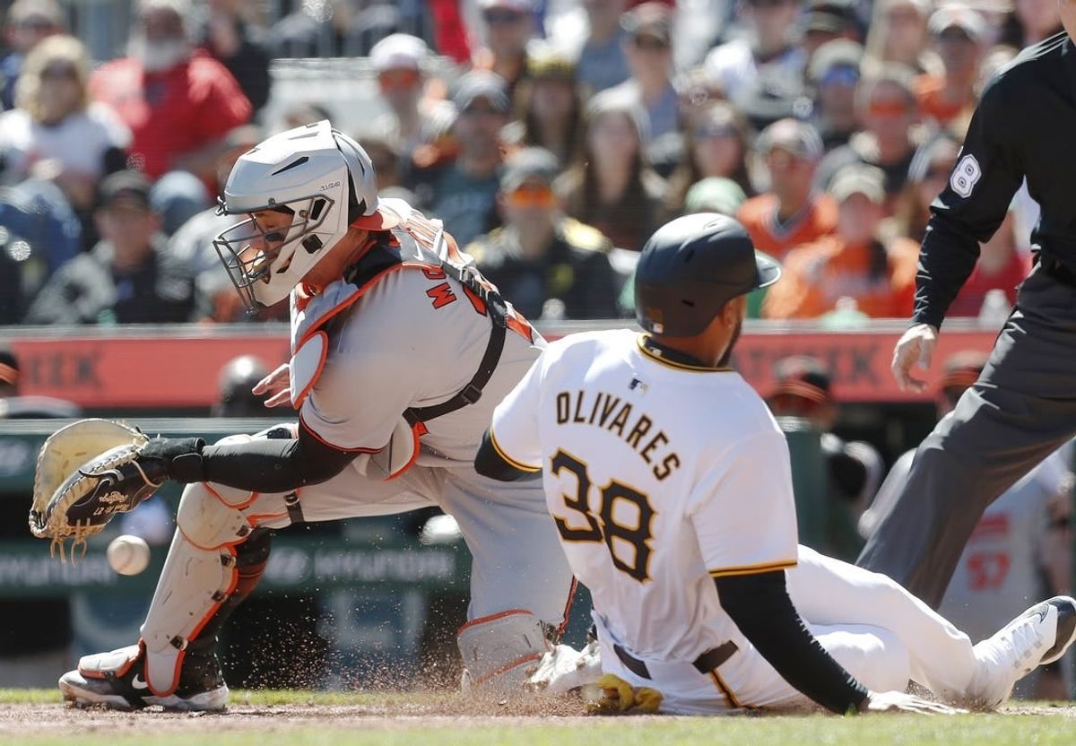 Apr 7, 2024; Pittsburgh, Pennsylvania, USA; Pittsburgh Pirates designated hitter Edward Olivares (right) slides home to score a run as Baltimore Orioles catcher James McCann (27) misses the catch during the fifth inning at PNC Park.