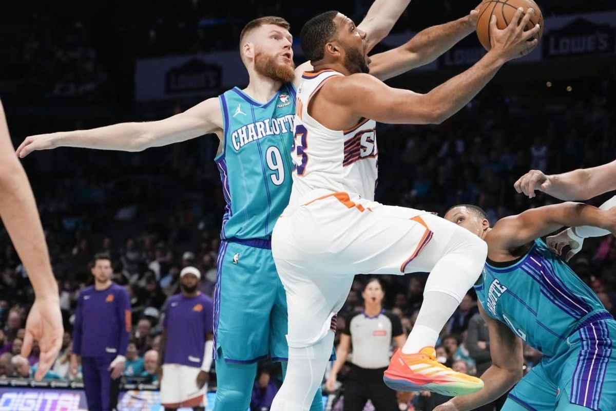 Mar 15, 2024; Charlotte, North Carolina, USA; Phoenix Suns guard Eric Gordon (23) drives to the basket against Charlotte Hornets forward Davis Bertans (9) during the first quarter at Spectrum Center.