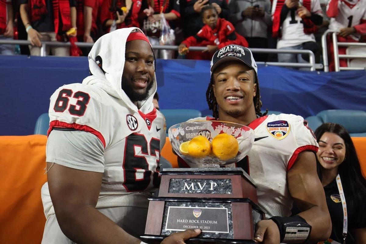 Dec 30, 2023; Miami Gardens, FL, USA; Georgia Bulldogs running back Kendall Milton (2) holds the MVP game trophy with offensive lineman Sedrick Van Pran (63)after the Capital One Orange Bowl at Hard Rock Stadium.