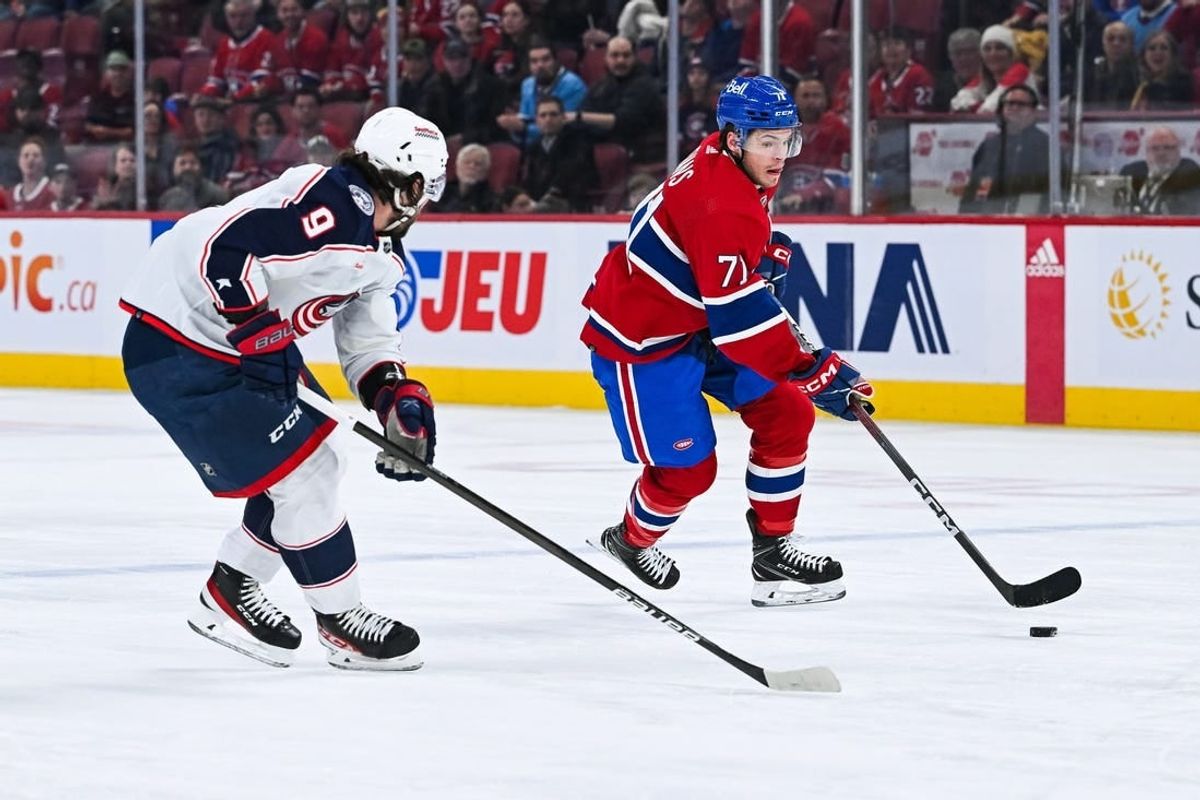 Mar 12, 2024; Montreal, Quebec, CAN; Montreal Canadiens center Jake Evans (71) plays the puck against Columbus Blue Jackets defenseman Ivan Provorov (9) during the first period at Bell Centre.