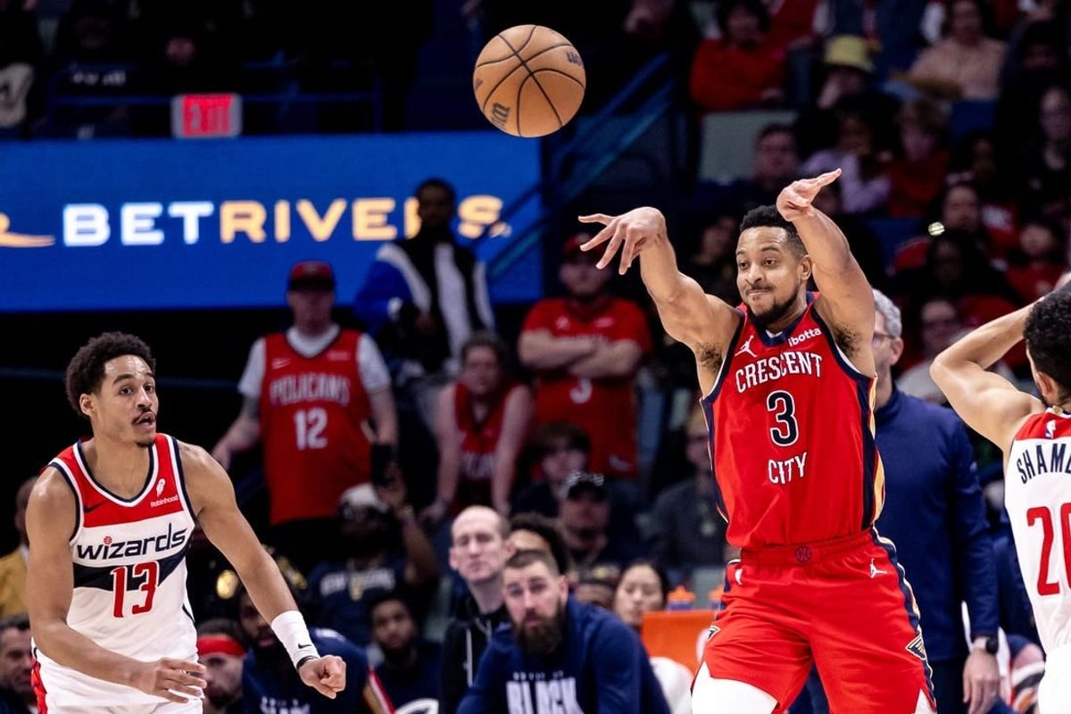 Feb 14, 2024; New Orleans, Louisiana, USA;  New Orleans Pelicans guard CJ McCollum (3) passes the ball against Washington Wizards guard Jordan Poole (13) during the second half at Smoothie King Center.