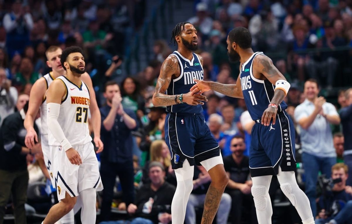 Mar 17, 2024; Dallas, Texas, USA;  Dallas Mavericks forward Derrick Jones Jr. (55) celebrates with Dallas Mavericks guard Kyrie Irving (11) in front of Denver Nuggets guard Jamal Murray (27) during the first quarter at American Airlines Center.