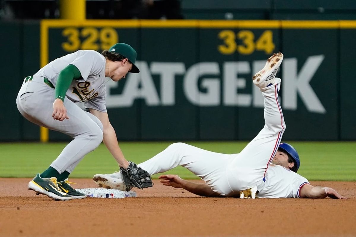 Apr 9, 2024; Arlington, Texas, USA; Oakland Athletics second baseman Zack Gelof (20) puts the tag on Texas Rangers shortstop Josh Smith (8) who was caught stealing on the play during the first inning Globe Life Field.