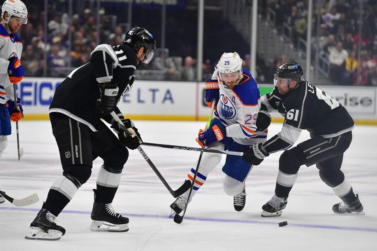 Dec 30, 2023; Los Angeles, California, USA; Edmonton Oilers center Leon Draisaitl (29) moves the puck against Los Angeles Kings center Trevor Lewis (61) and center Anze Kopitar (11) during the first period at Crypto.com Arena.