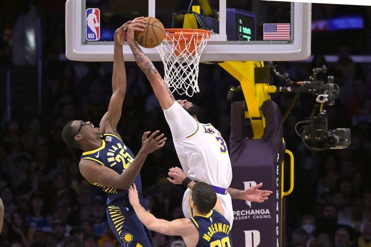 Mar 24, 2024; Los Angeles, California, USA;   Los Angeles Lakers forward Anthony Davis (3) grabs his own rebound and scores past Indiana Pacers forward Jalen Smith (25) in the first half at Crypto.com Arena.
