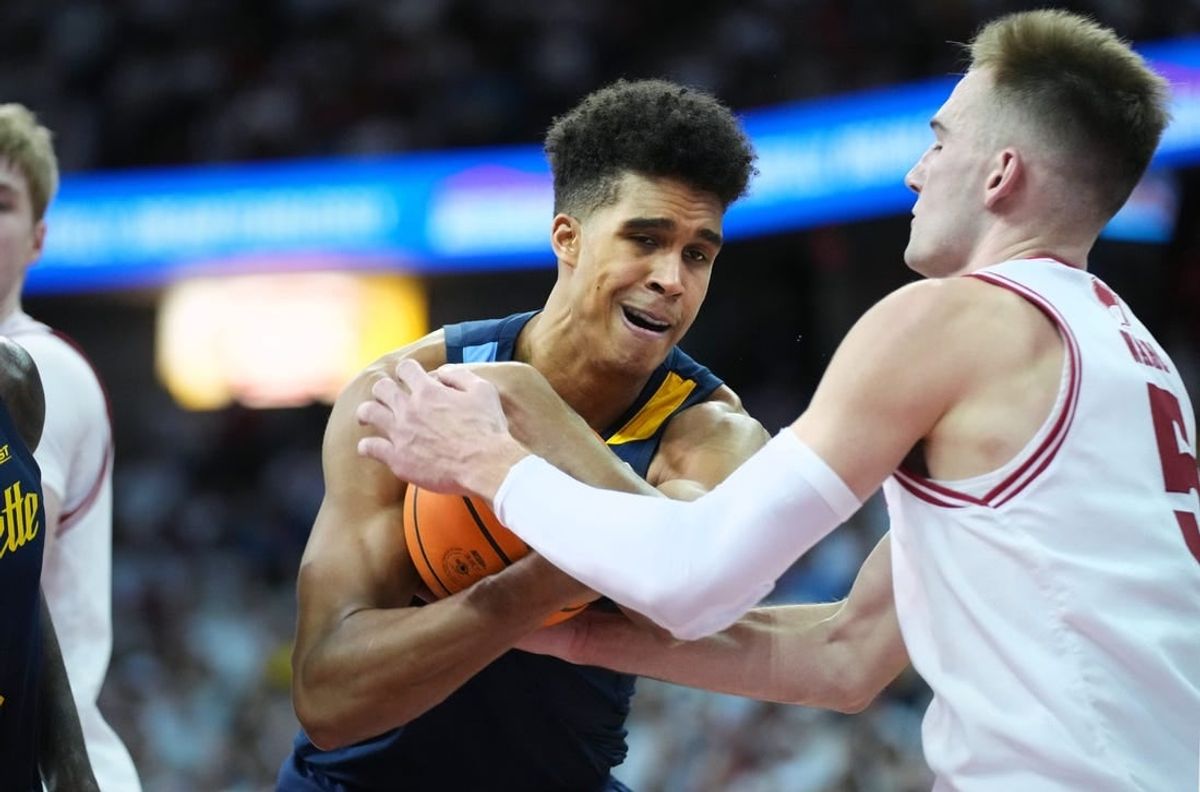 Dec 2, 2023; Madison, Wisconsin, USA;  Marquette Golden Eagles forward Oso Ighodaro (13) and Wisconsin Badgers forward Tyler Wahl (5) battle for the ball during the second half at the Kohl Center.