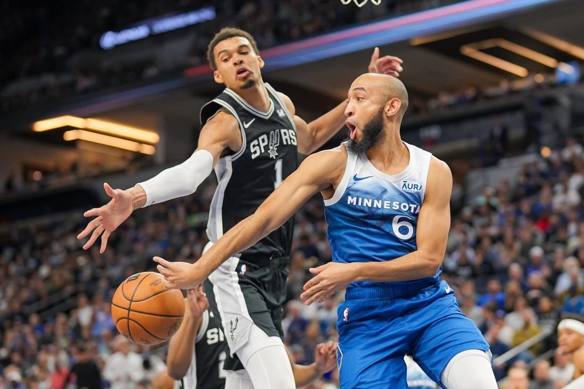 Feb 27, 2024; Minneapolis, Minnesota, USA; Minnesota Timberwolves guard Jordan McLaughlin (6) passes against the San Antonio Spurs center Victor Wembanyama (1) in the second quarter at Target Center.