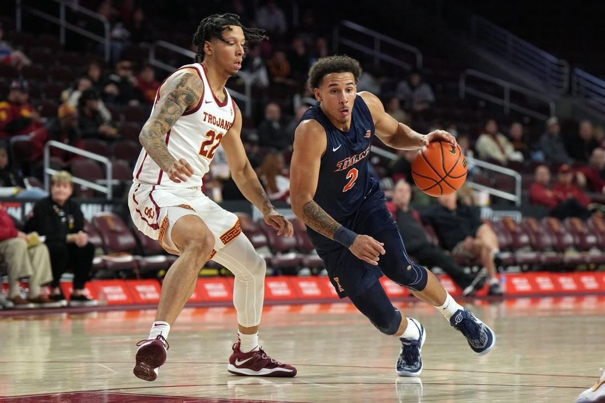 Dec 7, 2022; Los Angeles, California, USA; Cal State Fullerton Titans guard Max Jones (2) dribbles the ball against Southern California Trojans guard Tre White (22) in the first half at Galen Center.