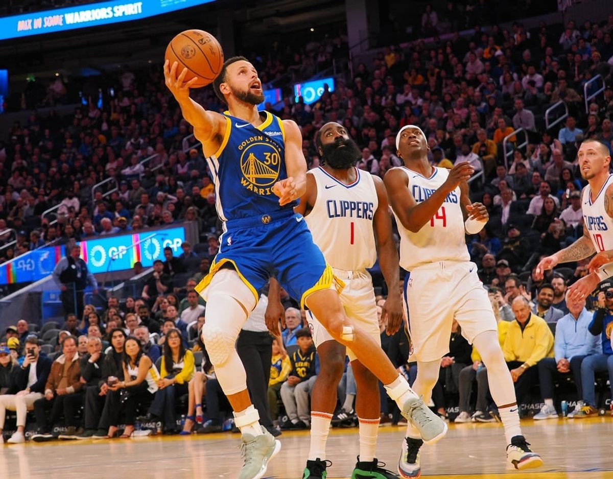 Nov 30, 2023; San Francisco, California, USA; Golden State Warriors guard Stephen Curry (30) scores against Los Angeles Clippers guard James Harden (1), guard Terance Mann (14) during the fourth quarter at Chase Center.