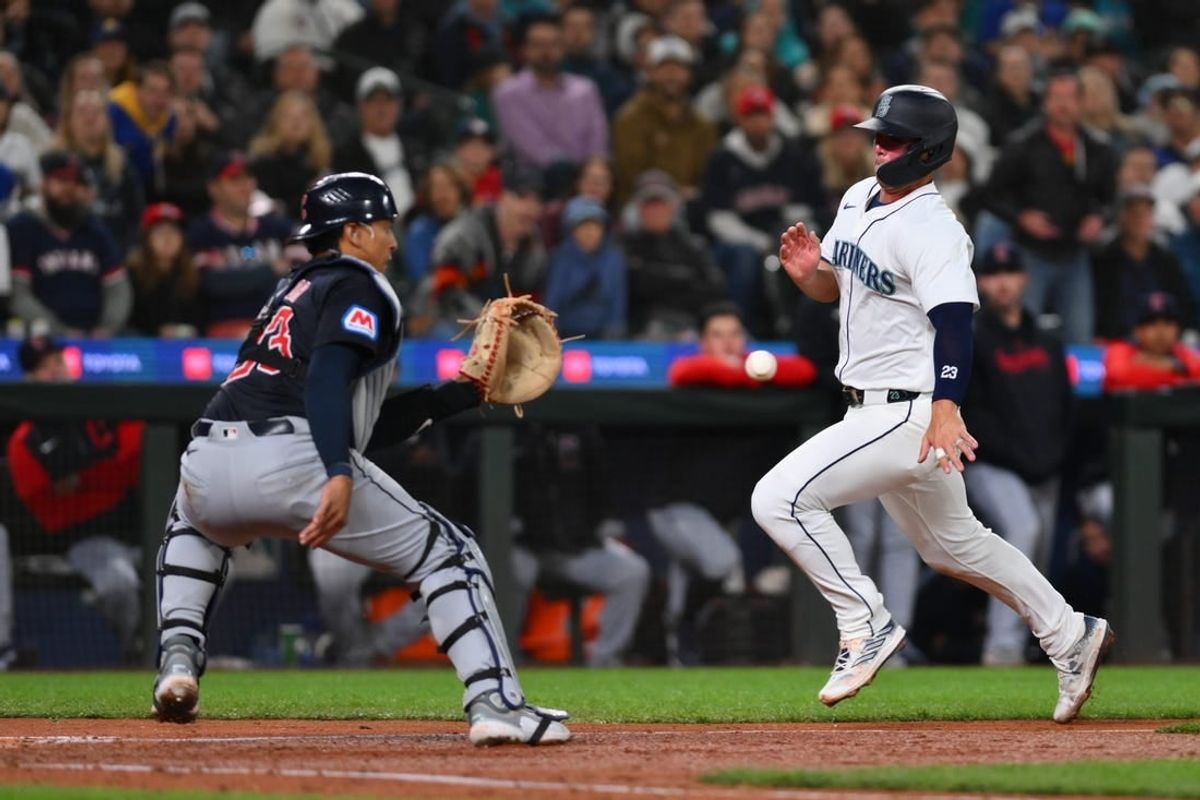Apr 1, 2024; Seattle, Washington, USA; Cleveland Guardians catcher Bo Naylor (23) catches the ball and later tags out Seattle Mariners first baseman Ty France (23) at home plate during the fourth inning at T-Mobile Park.