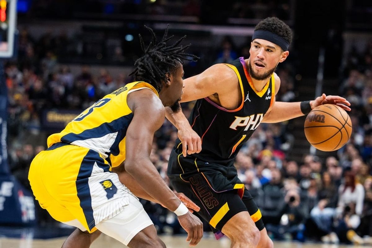 Jan 26, 2024; Indianapolis, Indiana, USA; Phoenix Suns guard Devin Booker (1) dribbles the ball while Indiana Pacers forward Aaron Nesmith (23) defends in the second half at Gainbridge Fieldhouse.