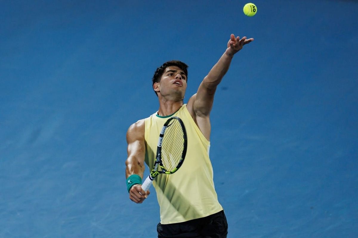 Jan 16, 2024; Melbourne, Victoria, Australia;   Carlos Alcaraz of Spain hits a shot against Richard Gasquet of France in the first round of the men s singles at the Australian Open.