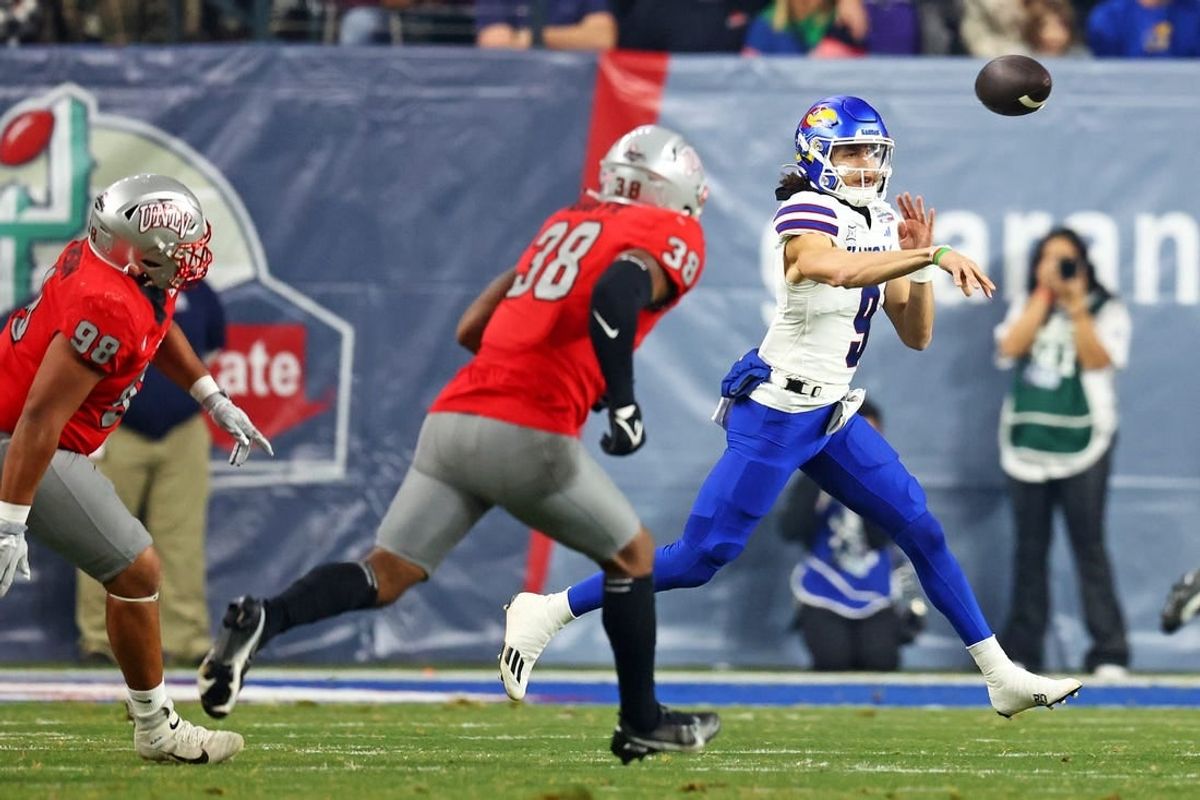 Dec 26, 2023; Phoenix, AZ, USA; Kansas Jayhawks quarterback Jason Bean (9) throws a pass against UNLV Rebels linebacker Marsel McDuffie (38) during the first quarter in the Guaranteed Rate Bowl at Chase Field.