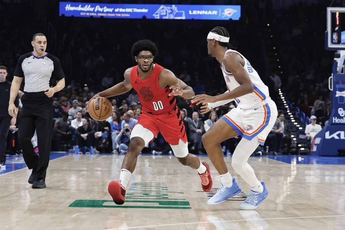 Jan 11, 2024; Oklahoma City, Oklahoma, USA; Portland Trail Blazers guard Scoot Henderson (00) drives down the court against Oklahoma City Thunder guard Shai Gilgeous-Alexander (2) during the second quarter at Paycom Center.