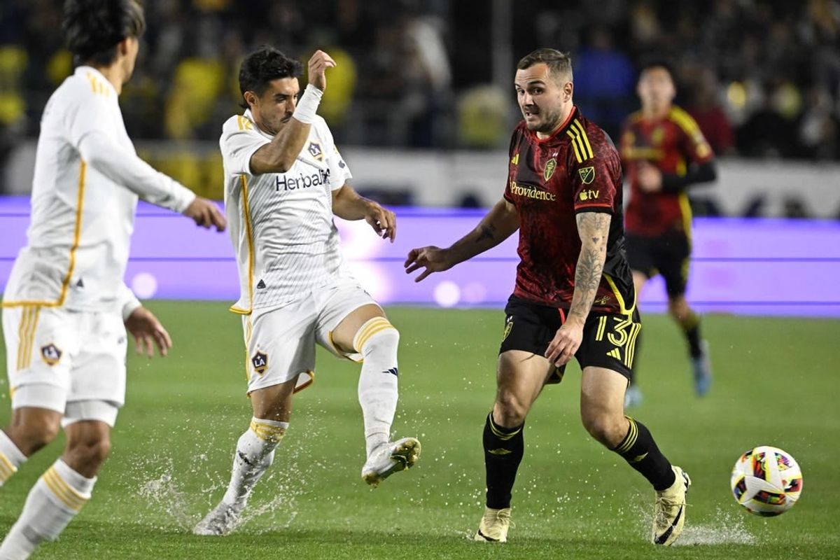 Mar 30, 2024; Carson, California, USA; LA Galaxy midfielder Gaston Brugman (5) battles for the ball against Seattle Sounders FC forward Jordan Morris (13) during the first half at Dignity Health Sports Park.