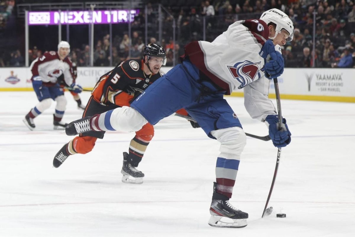 Dec 2, 2023; Anaheim, California, USA; Colorado Avalanche right wing Mikko Rantanen (96) attempts a shot as Anaheim Ducks defensemen Urho Vaakanainen (5) pursues during the first period at Honda Center.