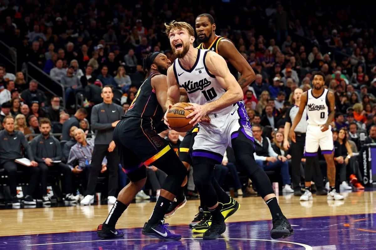 Jan 16, 2024; Phoenix, Arizona, USA; Sacramento Kings forward Domantas Sabonis (10) drives to the basket against Phoenix Suns forward Josh Okogie (2) and forward Nassir Little (25) during the fourth quarter at Footprint Center.