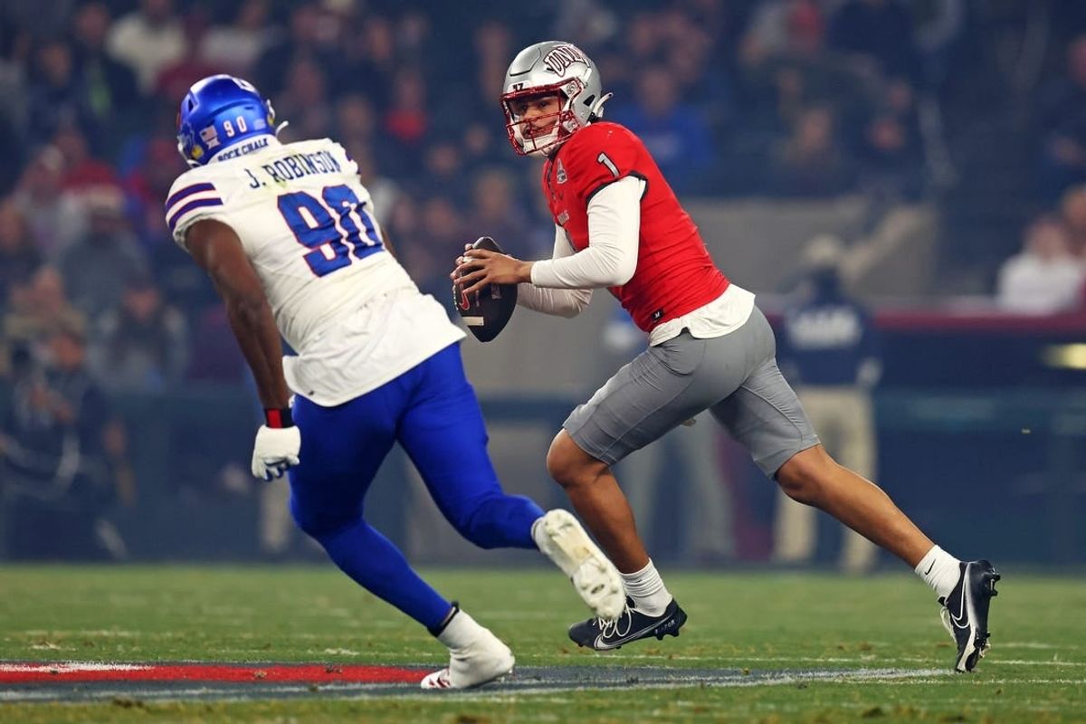 Dec 26, 2023; Phoenix, AZ, USA; UNLV Rebels quarterback Jayden Maiava (1) roles out to pass against Kansas Jayhawks defensive lineman Jereme Robinson (90) during the first quarter in the Guaranteed Rate Bowl at Chase Field.