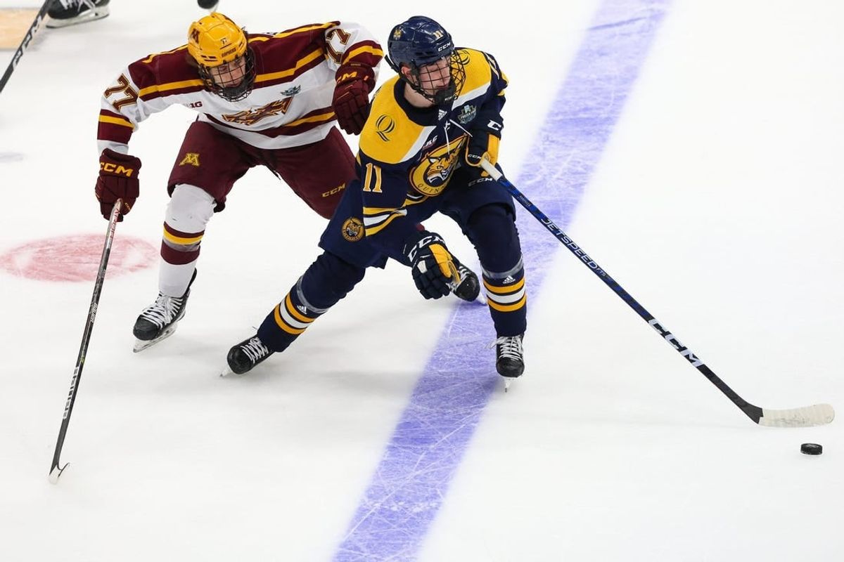 Apr 8, 2023; Tampa, Florida, USA; Quinnipiac forward Collin Graf (11) controls the puck  from Minnesota forward Rhett Pitlick (77) in the first period  during the national championship game of the 2023 Frozen Four college ice hockey tournament at Amalie Arena.