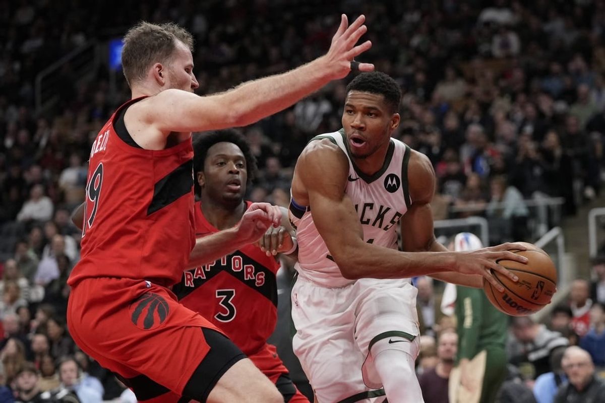 Nov 1, 2023; Toronto, Ontario, CAN; Milwaukee Bucks forward Giannis Antetokounmpo (34) tries to pass the ball against Toronto Raptors center Jakob Poeltl (19) during the second half at Scotiabank Arena.
