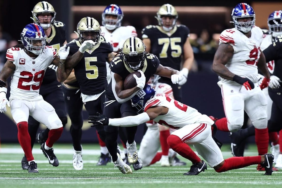 Dec 17, 2023; New Orleans, Louisiana, USA; New Orleans Saints running back Alvin Kamara (41) is tackled by New York Giants safety Jason Pinnock (27) during the second half at Caesars Superdome.