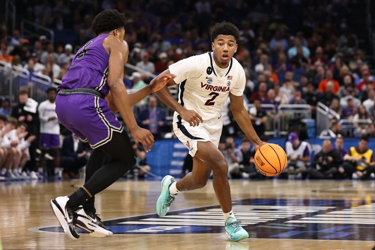 Mar 16, 2023; Orlando, FL, USA; Virginia Cavaliers guard Reece Beekman (2) dribbles the ball while defended by Furman Paladins guard Marcus Foster (5) during the second half at Amway Center.