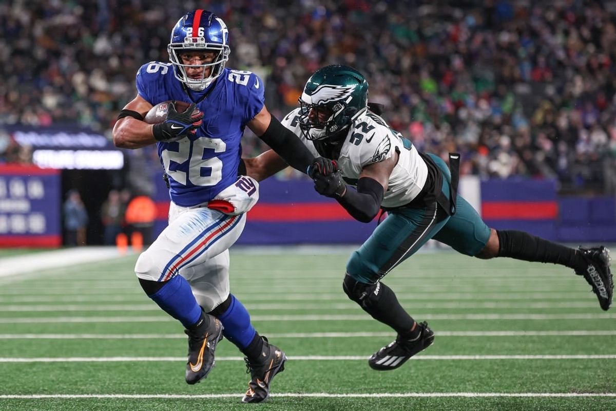 Jan 7, 2024; East Rutherford, New Jersey, USA; New York Giants running back Saquon Barkley (26) breaks a tackle by Philadelphia Eagles linebacker Zach Cunningham (52) for a rushing touchdown during the first half at MetLife Stadium.