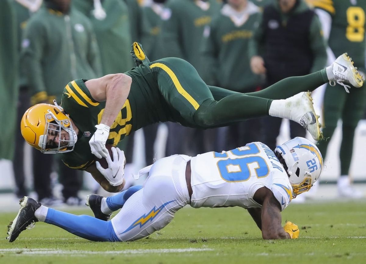 Sunday, November 19, 2023; Green Bay, WI; Green Bay Packers tight end Luke Musgrave (88) is upended by Los Angeles Chargers cornerback Asante Samuel Jr. (26) during the game at Lambeau Field.