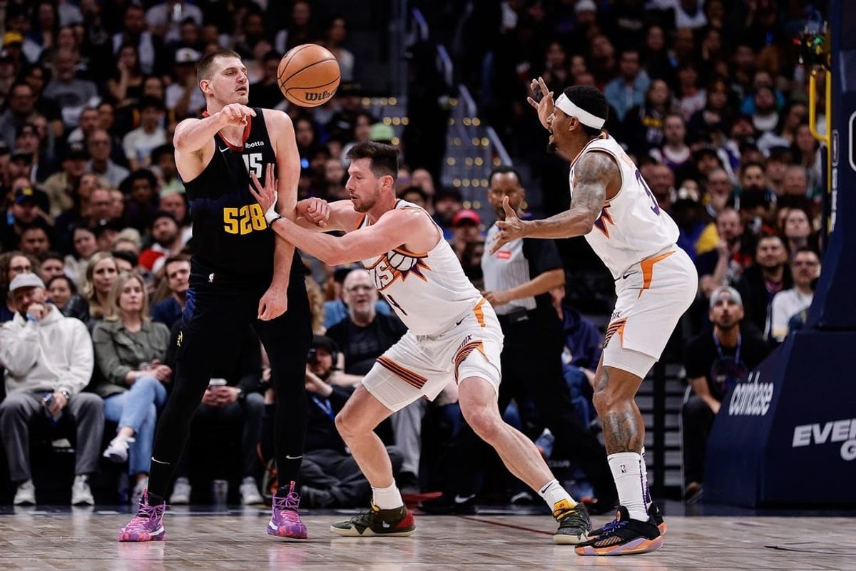 Mar 27, 2024; Denver, Colorado, USA; Denver Nuggets center Nikola Jokic (15) passes the ball against Phoenix Suns forward Drew Eubanks (14) and guard Bradley Beal (3) in the third quarter at Ball Arena.