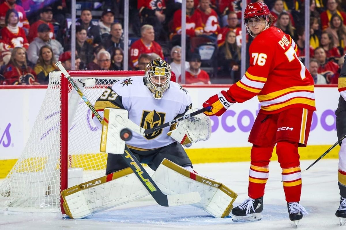 Nov 27, 2023; Calgary, Alberta, CAN; Vegas Golden Knights goaltender Adin Hill (33) guards his net as Calgary Flames center Martin Pospisil (76) tries to redirect the puck during the second period at Scotiabank Saddledome.