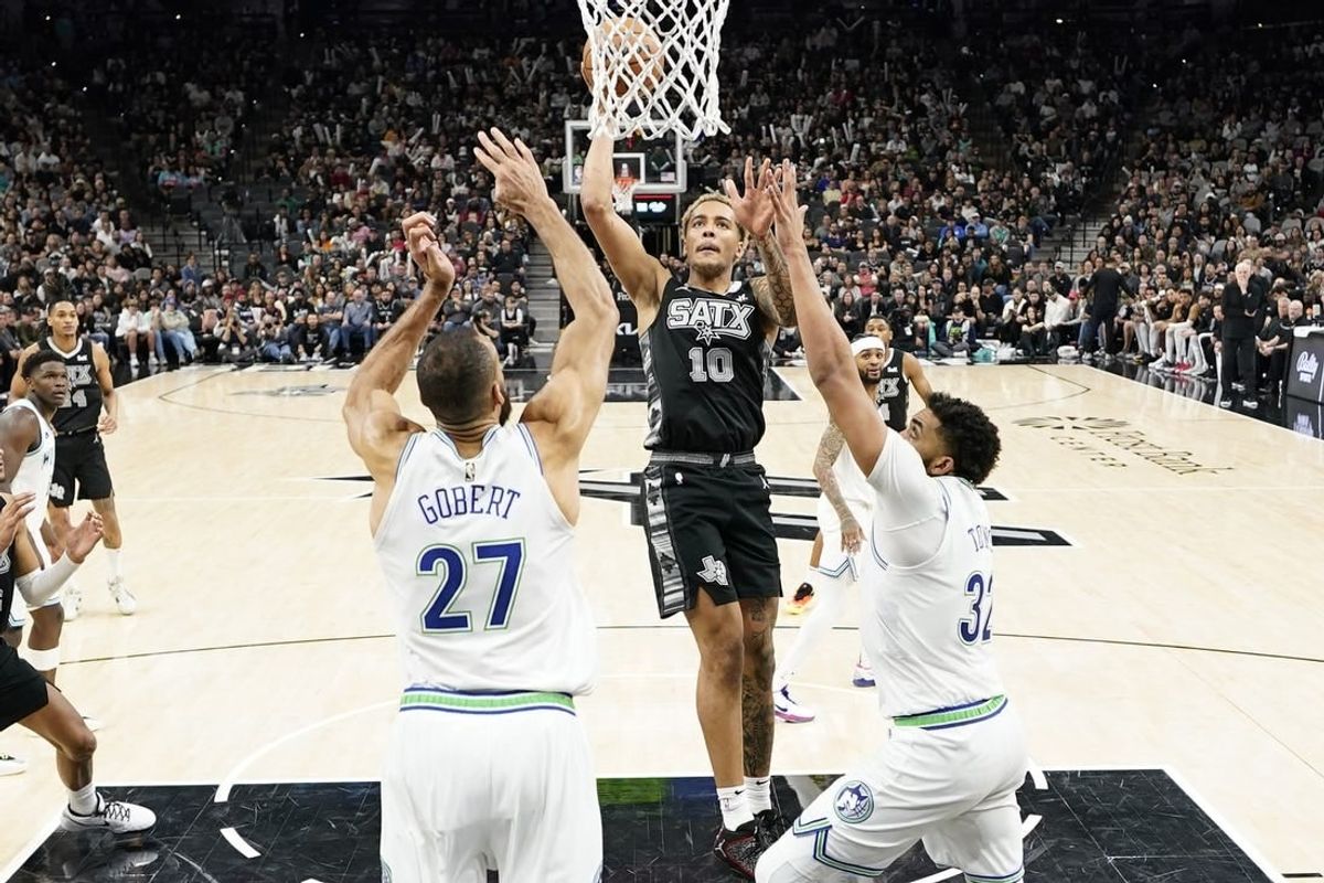 Jan 27, 2024; San Antonio, Texas, USA; San Antonio Spurs forward Jeremy Sochan (10) drives to the basket past Minnesota Timberwolves centers Rudy Gobert (27) and Karl-Anthony Towns (32) during the second half at Frost Bank Center.