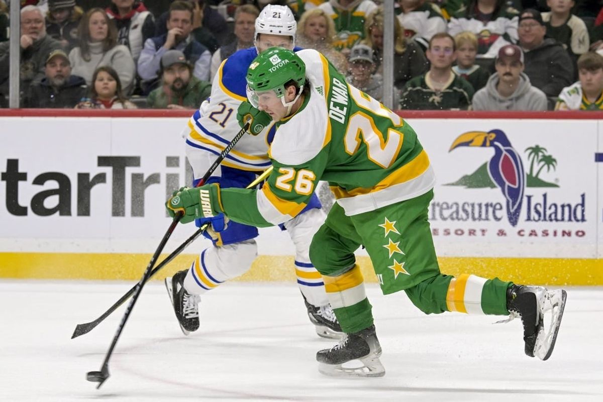 Feb 17, 2024; Saint Paul, Minnesota, USA;  Minnesota Wild forward Connor Dewar (26) clears the puck on a penalty kill against the Buffalo Sabres during the first period at Xcel Energy Center.