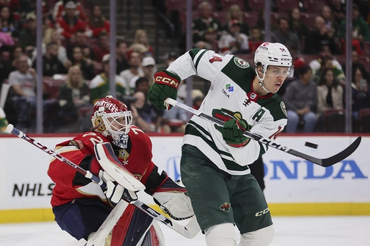 Jan 19, 2024; Sunrise, Florida, USA; Minnesota Wild center Joel Eriksson Ek (14) attempts to deflect the puck against Florida Panthers goaltender Sergei Bobrovsky (72) during the first period at Amerant Bank Arena.