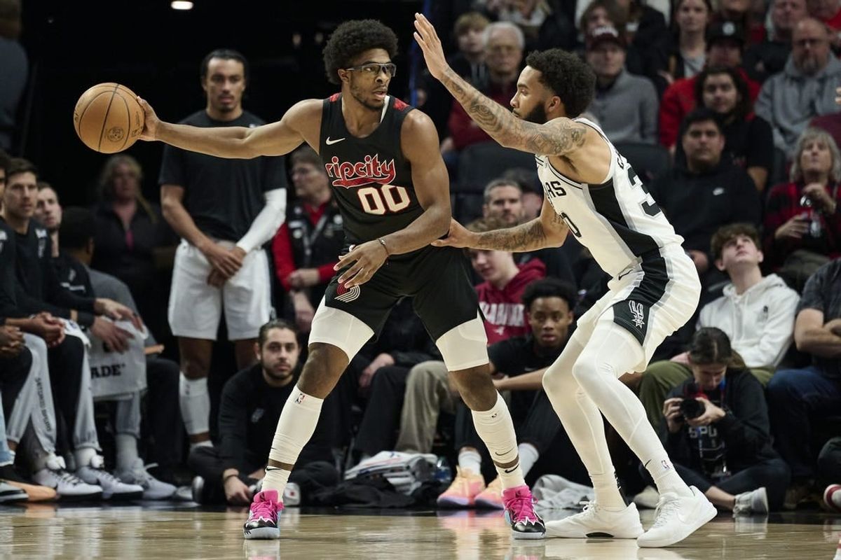 Dec 29, 2023; Portland, Oregon, USA; Portland Trail Blazers guard Scoot Henderson (00) looks to pass the ball during the first half against San Antonio Spurs forward Julian Champagnie (30) at Moda Center.