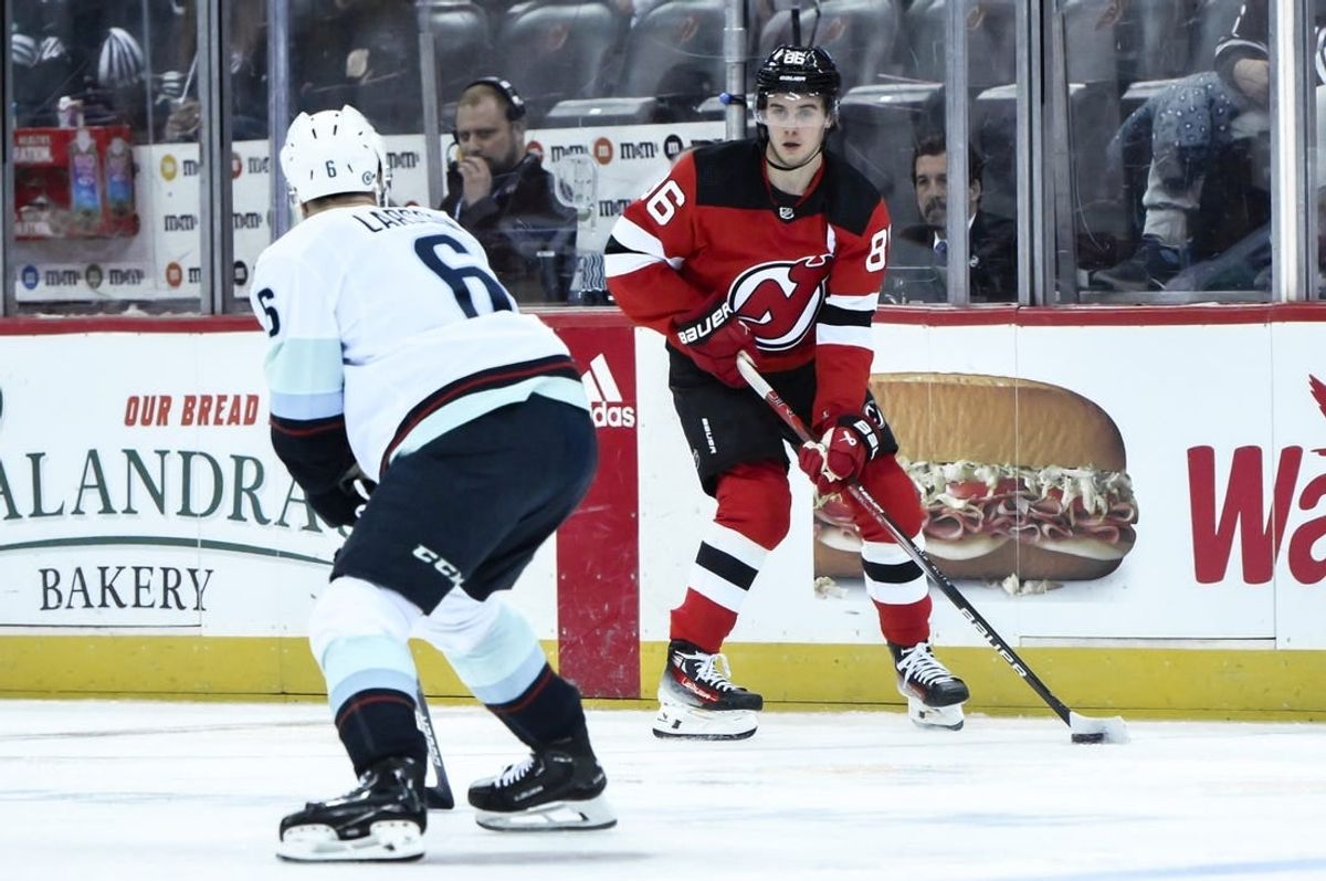 Feb 12, 2024; Newark, New Jersey, USA; New Jersey Devils center Jack Hughes (86) skates with the puck while being defended by Seattle Kraken defenseman Adam Larsson (6) during the second period at Prudential Center.