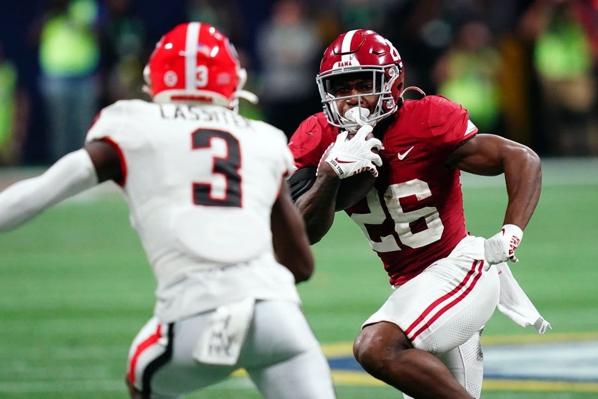 Dec 2, 2023; Atlanta, GA, USA;  Alabama Crimson Tide running back Jam Miller (26) runs against Georgia Bulldogs defensive back Kamari Lassiter (3) in the fourth quarter of the SEC Championship at Mercedes-Benz Stadium.