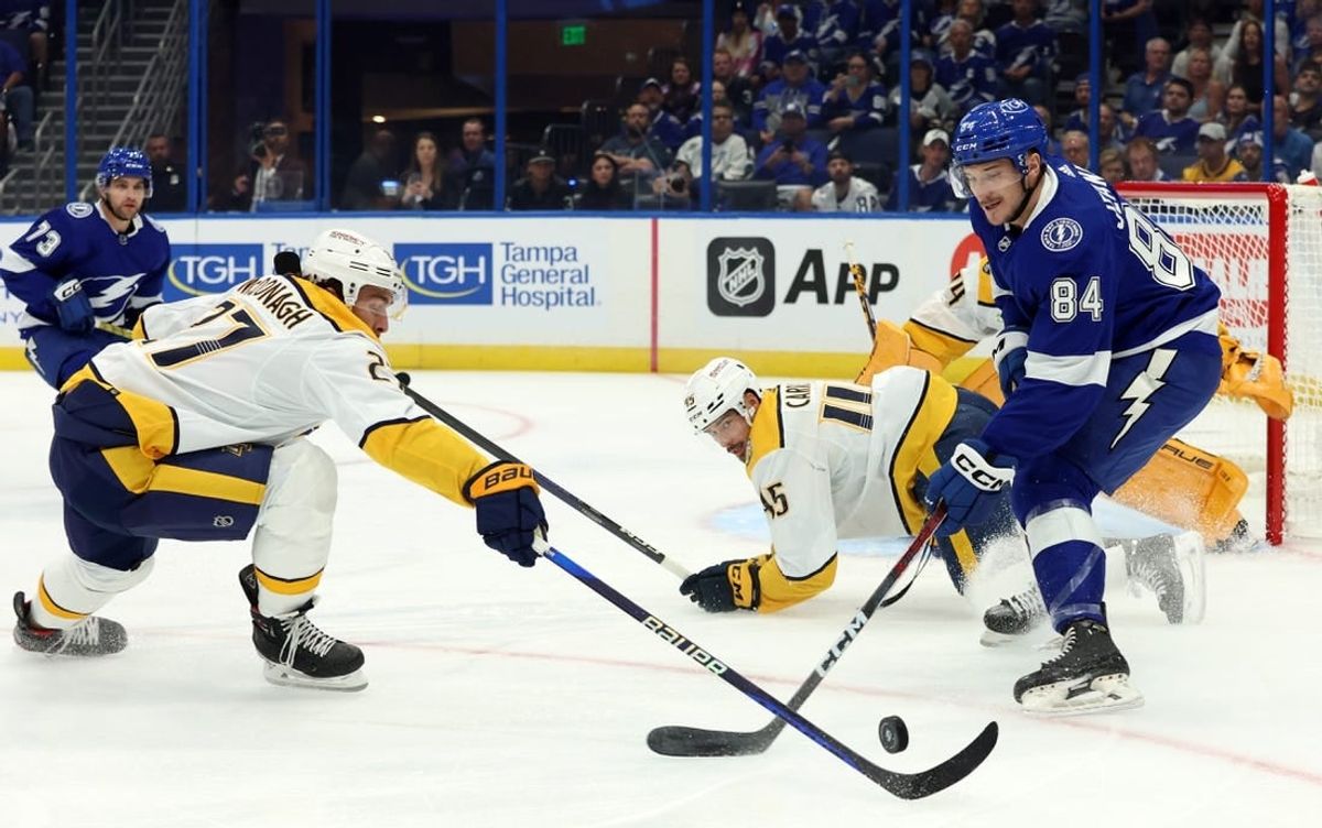 Oct 10, 2023; Tampa, Florida, USA; Tampa Bay Lightning left wing Tanner Jeannot (84) skates with the puck as Nashville Predators defenseman Ryan McDonagh (27) defends during the first period at Amalie Arena.