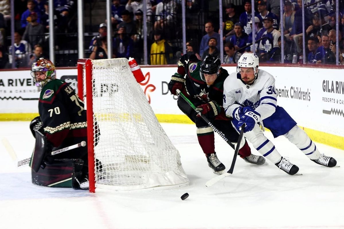 Feb 21, 2024; Tempe, Arizona, USA; Toronto Maple Leafs center Auston Matthews (34) moves the puck against the net against Arizona Coyotes defenseman Juuso Valimaki (4) during the first period at Mullett Arena.
