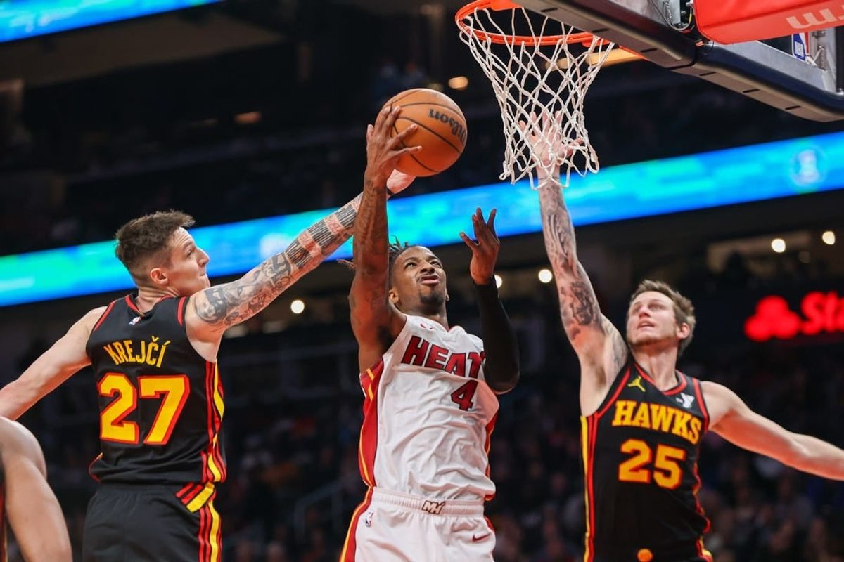 Apr 9, 2024; Atlanta, Georgia, USA; Miami Heat guard Delon Wright (4) shoots past Atlanta Hawks guard Vit Krejci (27) and guard Garrison Mathews (25) in the second quarter at State Farm Arena.