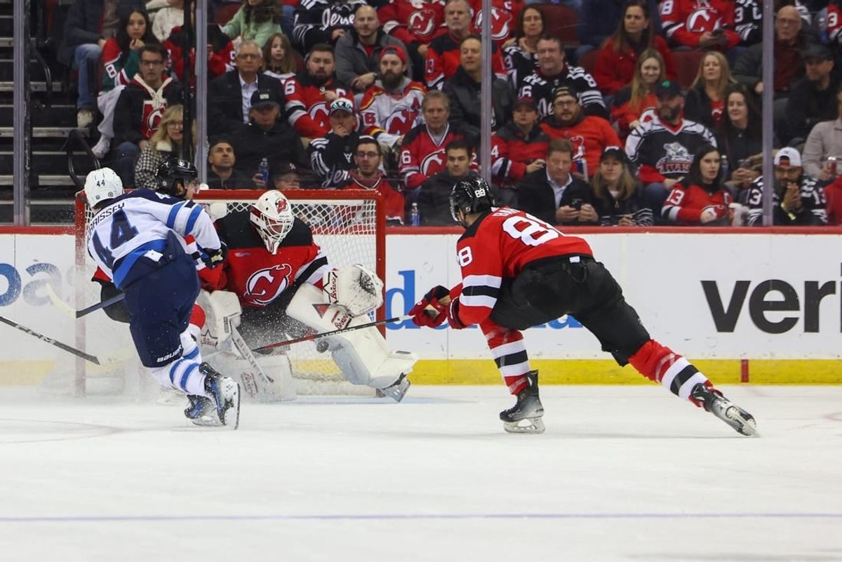 Mar 21, 2024; Newark, New Jersey, USA; New Jersey Devils goaltender Jake Allen (34) makes a save on Winnipeg Jets defenseman Josh Morrissey (44) during the second period at Prudential Center.