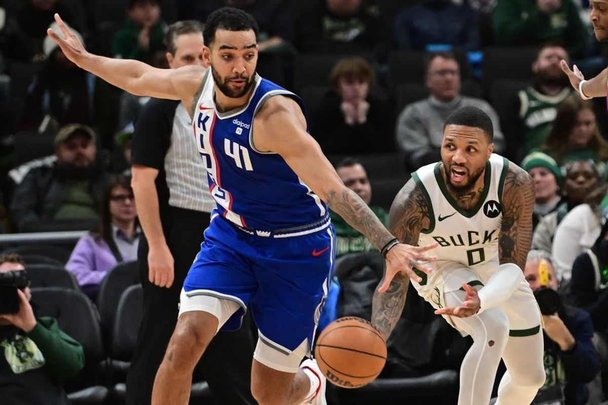 Jan 14, 2024; Milwaukee, Wisconsin, USA;  Milwaukee Bucks guard Damian Lillard (0) passes the ball away from Sacramento Kings forward Trey Lyles (41) in overtime at Fiserv Forum.