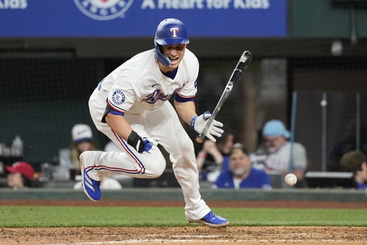 Apr 24, 2024; Arlington, Texas, USA; Texas Rangers shortstop Corey Seager (5) reacts after getting hit by a pitch thrown by Seattle Mariners pitcher Austin Voth (not shown) during the seventh inning at Globe Life Field.