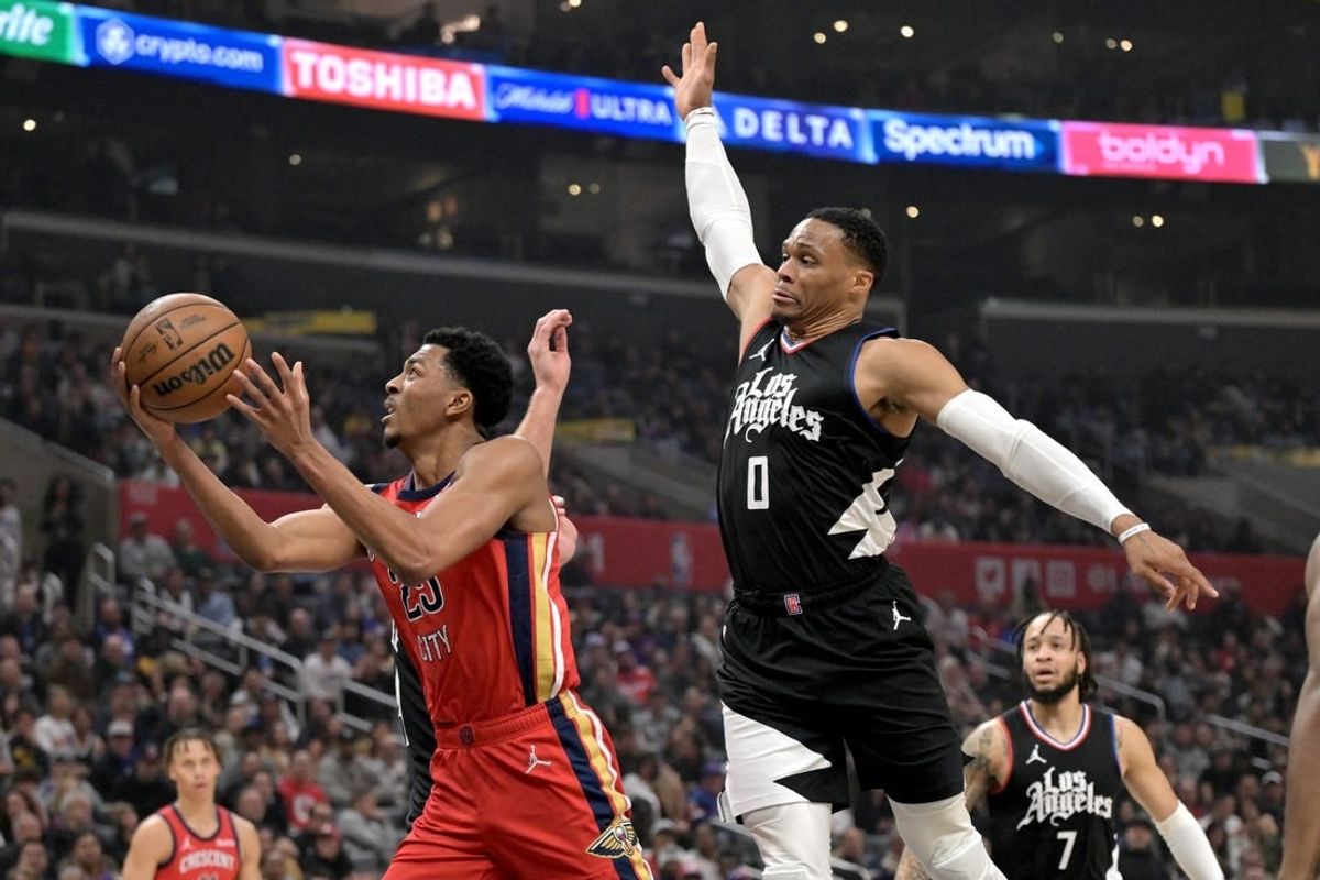 Feb 7, 2024; Los Angeles, California, USA; New Orleans Pelicans guard Jordan Hawkins (24) drives past Los Angeles Clippers guard Russell Westbrook (0) reach for a rebound in the first half at Crypto.com Arena.