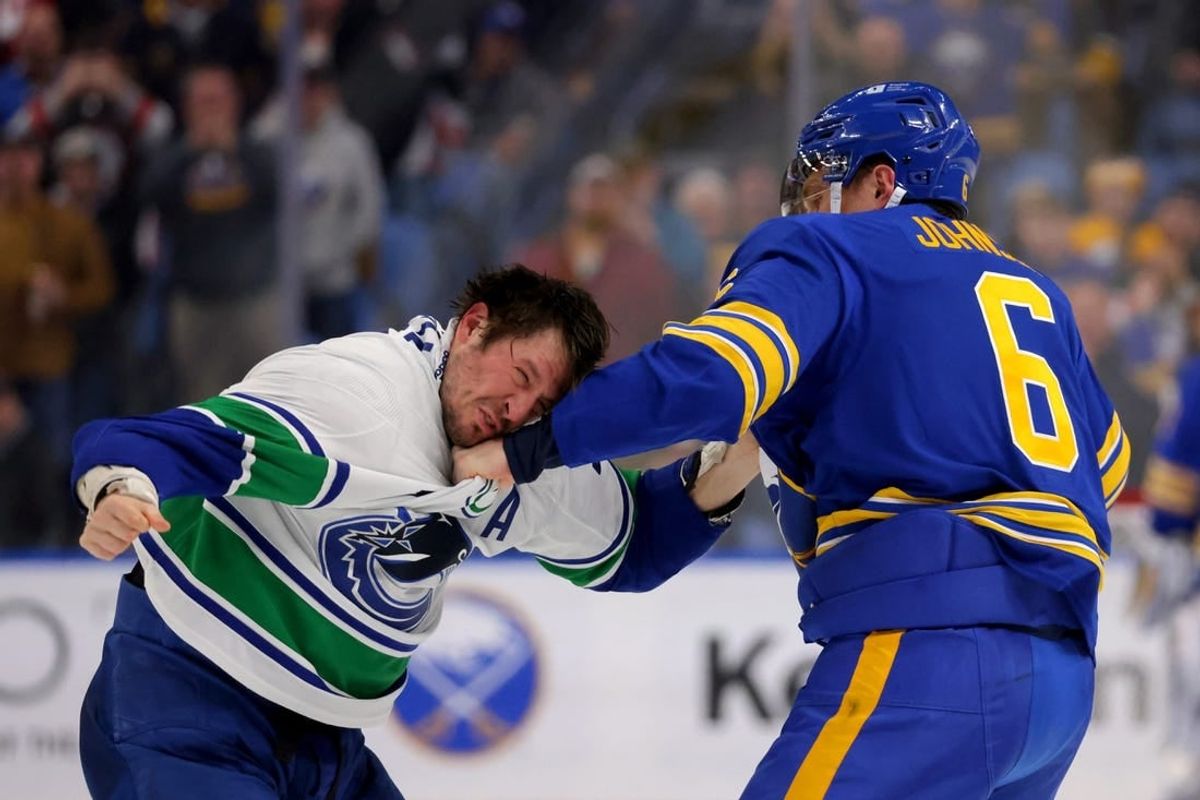 Jan 13, 2024; Buffalo, New York, USA;  Buffalo Sabres defenseman Erik Johnson (6) and Vancouver Canucks center J.T. Miller (9) fight during the second period at KeyBank Center.
