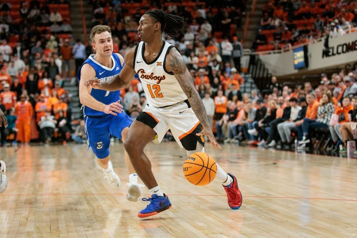 Nov 30, 2023; Stillwater, Oklahoma, USA; Oklahoma State Cowboys guard Javon Small (12) drives to the basket around Creighton Bluejays guard Steven Ashworth (1) during the first half at Gallagher-Iba Arena.