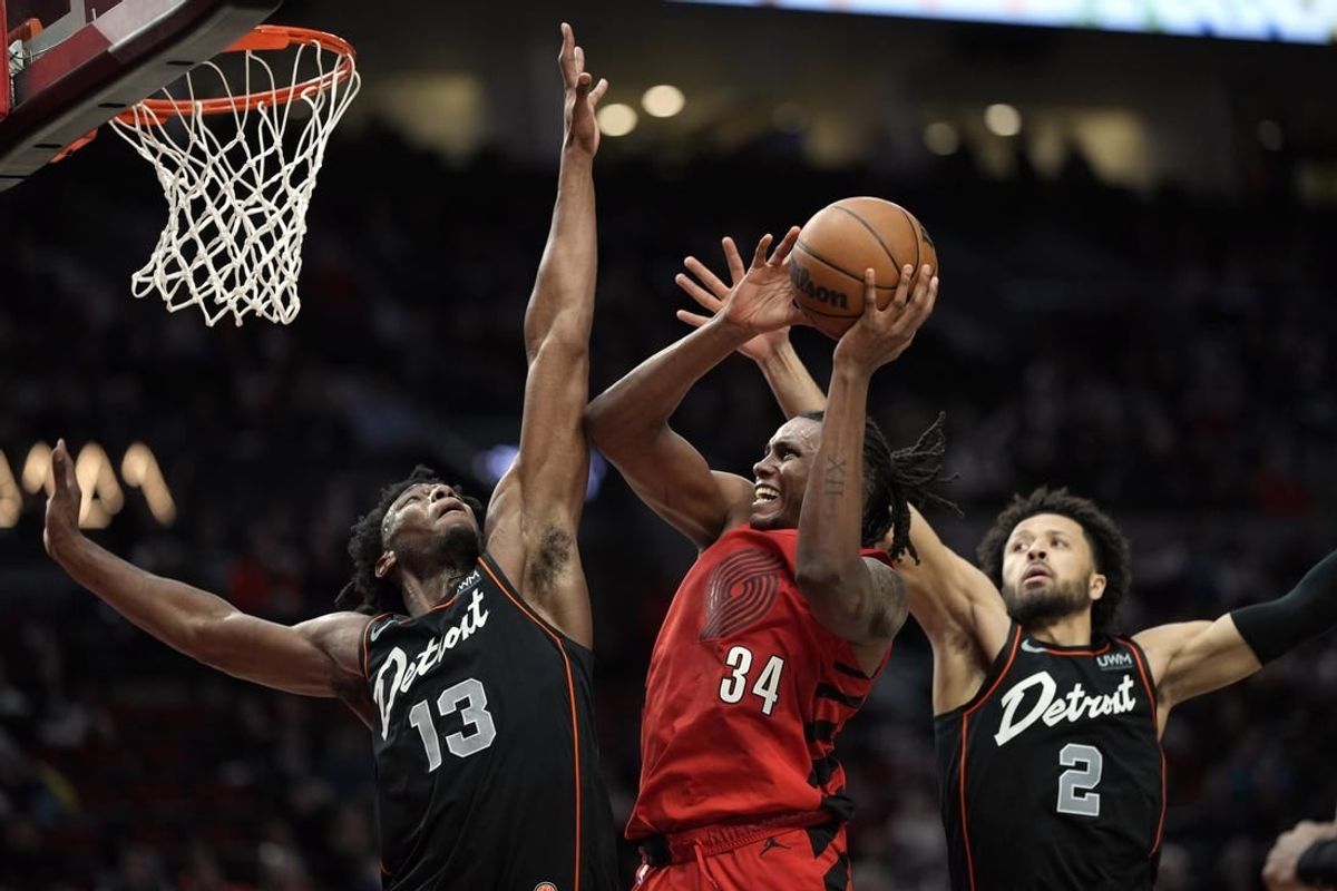 Feb 8, 2024; Portland, Oregon, USA; Portland Trail Blazers forward Jabari Walker (34) shoots the ball against Detroit Pistons center James Wiseman (13) and point guard Cade Cunningham (2) during the second half at Moda Center.